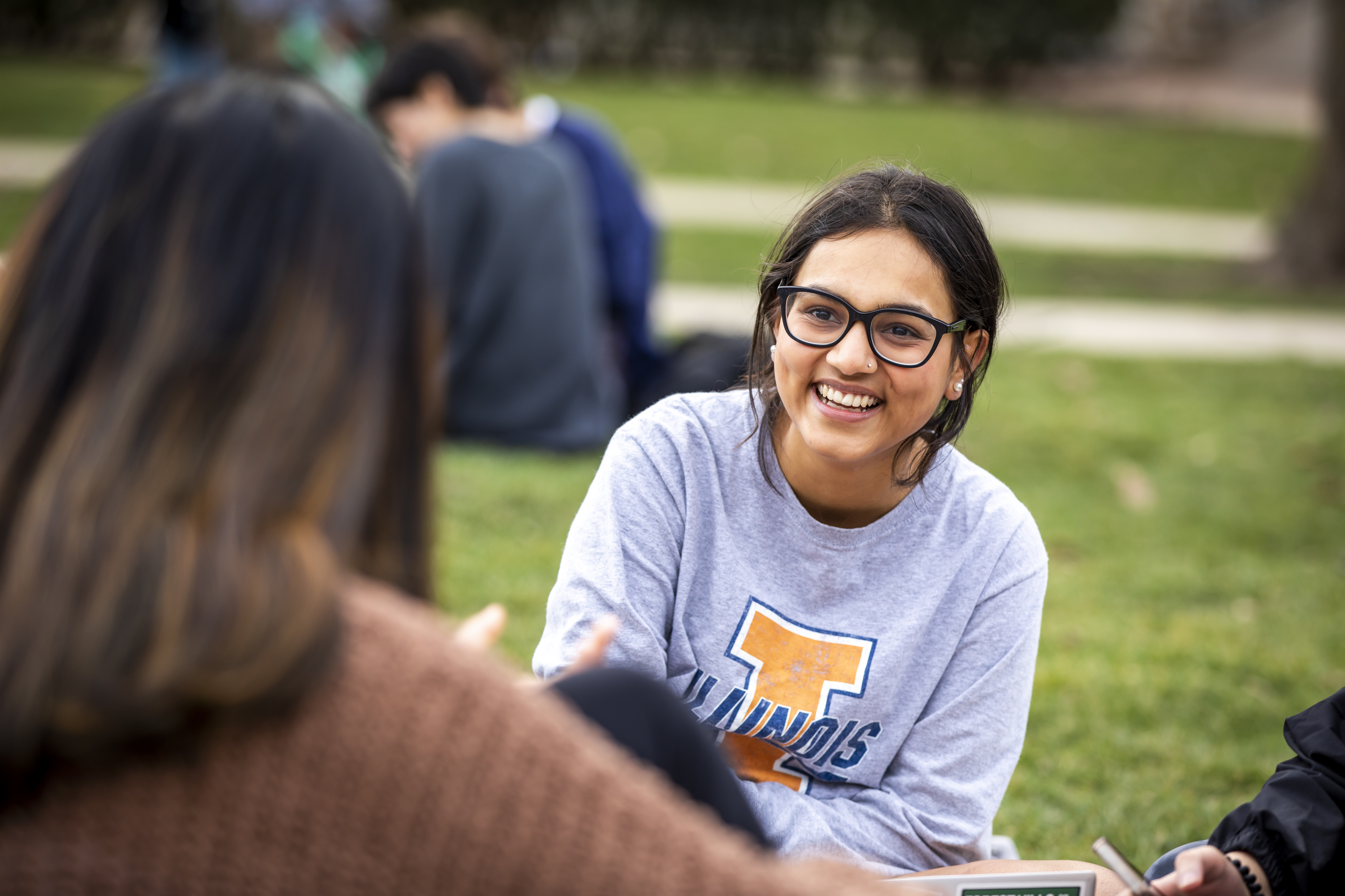 student sitting in quad smiling